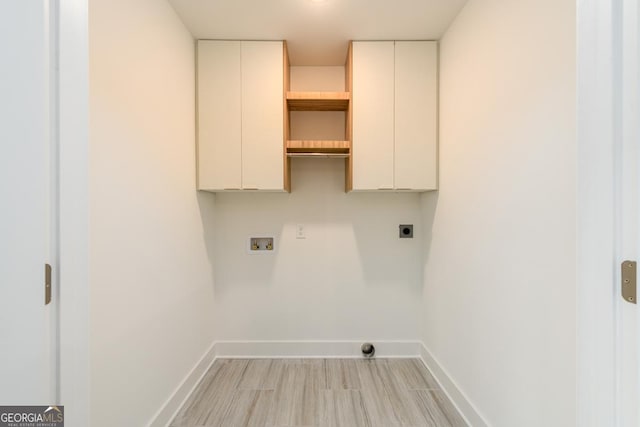 clothes washing area with cabinets, electric dryer hookup, and washer hookup