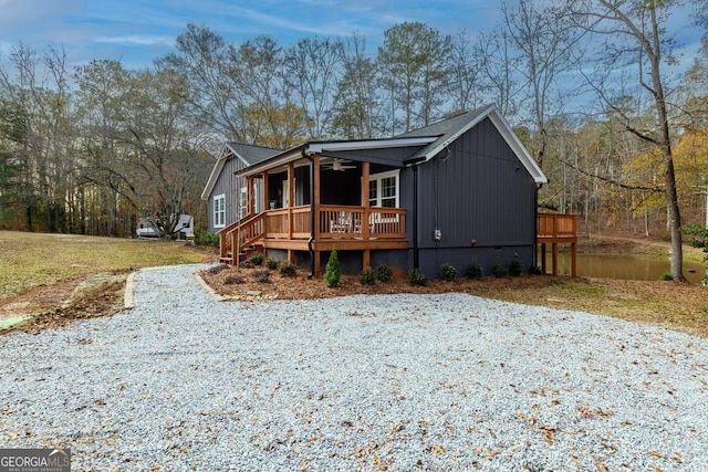 view of front of home featuring a deck with water view and ceiling fan