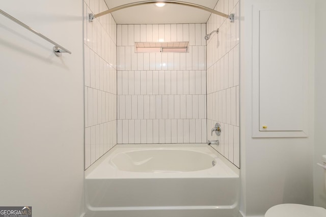 bathroom featuring tiled shower / bath and toilet