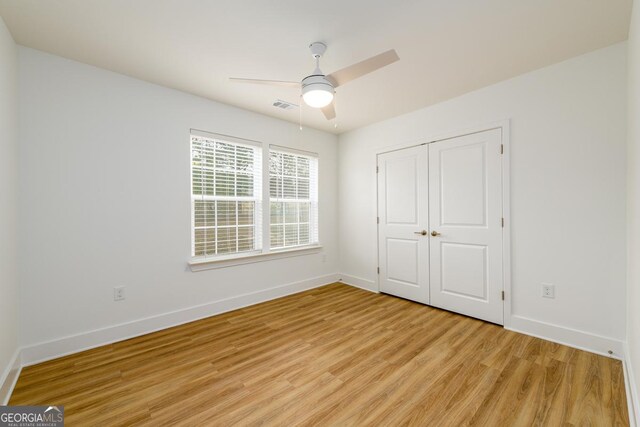 unfurnished bedroom featuring light wood-type flooring, a closet, and ceiling fan