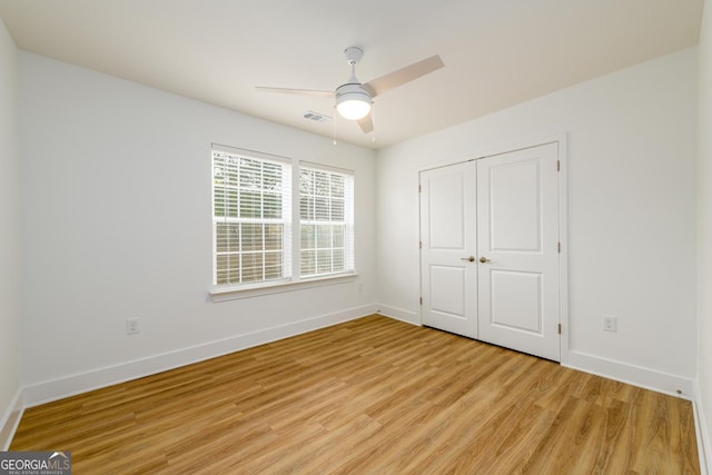 unfurnished bedroom with ceiling fan, light hardwood / wood-style floors, and a closet