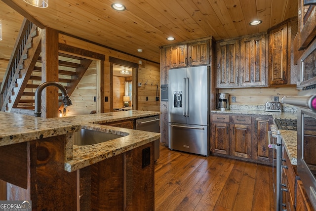 kitchen featuring wood ceiling, wooden walls, dark hardwood / wood-style flooring, and stainless steel appliances