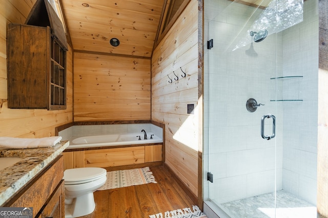 full bathroom with vanity, wood walls, wood-type flooring, and shower with separate bathtub