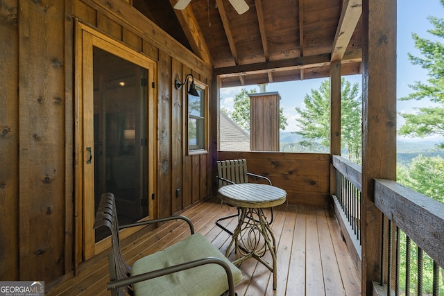 sunroom / solarium with lofted ceiling with beams, ceiling fan, and wooden ceiling