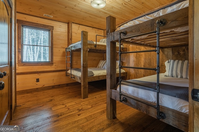 bedroom featuring hardwood / wood-style floors, wood ceiling, and wooden walls