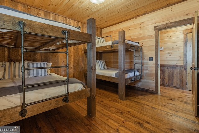 bedroom with wood ceiling, wood-type flooring, and wooden walls