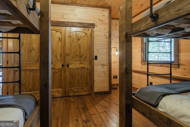 bedroom with wood-type flooring, wooden walls, and wooden ceiling