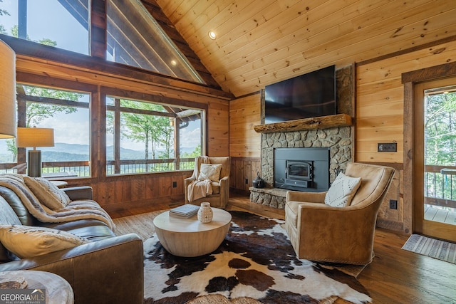 living room featuring a wood stove, wood walls, hardwood / wood-style floors, and wood ceiling