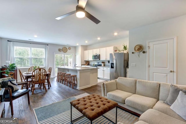 living room with ceiling fan and dark hardwood / wood-style floors