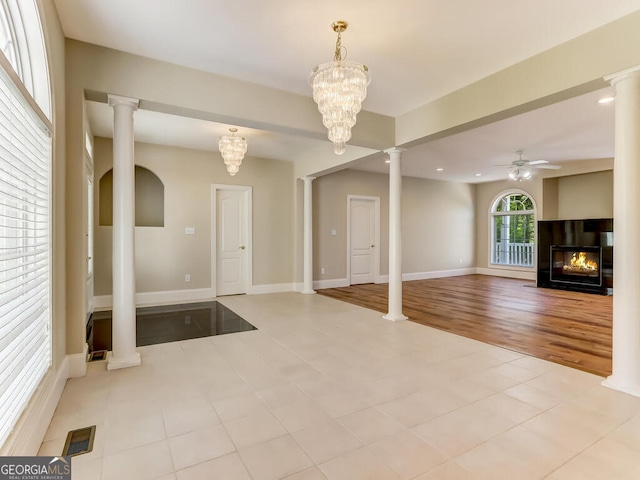 interior space with ceiling fan with notable chandelier and light hardwood / wood-style floors