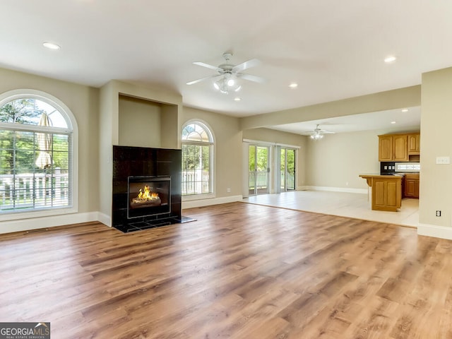 unfurnished living room with a fireplace, light hardwood / wood-style flooring, and plenty of natural light