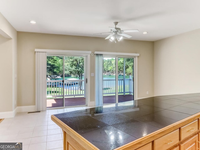 kitchen featuring light brown cabinetry, light tile patterned floors, and ceiling fan