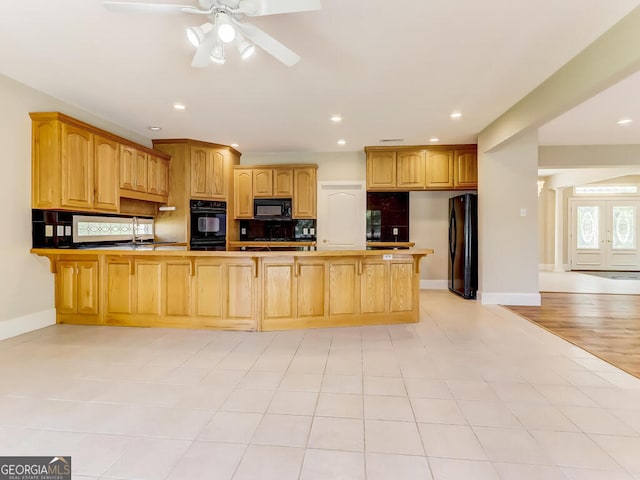 kitchen featuring ceiling fan, sink, kitchen peninsula, light hardwood / wood-style floors, and black appliances