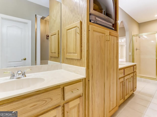 bathroom with decorative columns, tile patterned flooring, vanity, and walk in shower