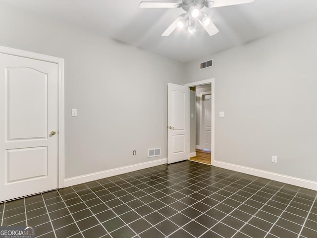 tiled spare room with ceiling fan