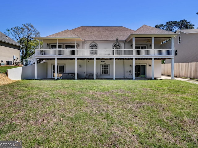 back of property with central AC unit, a yard, a jacuzzi, and a patio