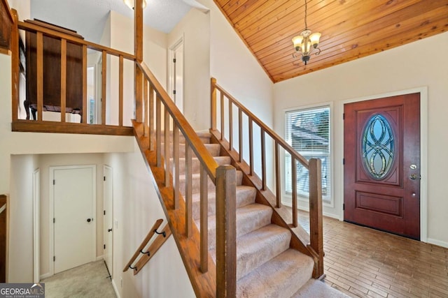 entryway featuring a chandelier, wood ceiling, lofted ceiling, and light hardwood / wood-style floors