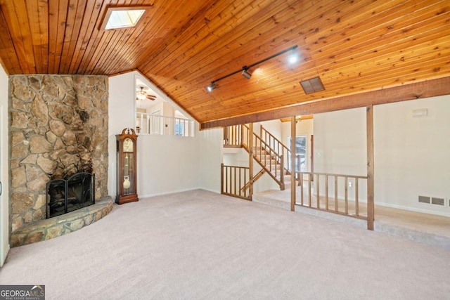 unfurnished living room featuring carpet flooring, lofted ceiling with skylight, ceiling fan, and wooden ceiling