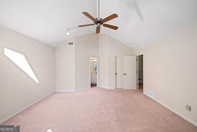 interior space with high vaulted ceiling, light colored carpet, ensuite bath, and ceiling fan