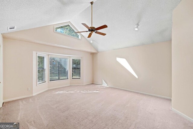 unfurnished room with high vaulted ceiling, ceiling fan, light colored carpet, and a wealth of natural light