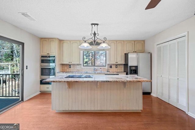 kitchen featuring a kitchen island, light hardwood / wood-style floors, hanging light fixtures, and stainless steel appliances