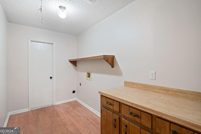 laundry room featuring a textured ceiling, washer hookup, light wood-type flooring, and hookup for an electric dryer