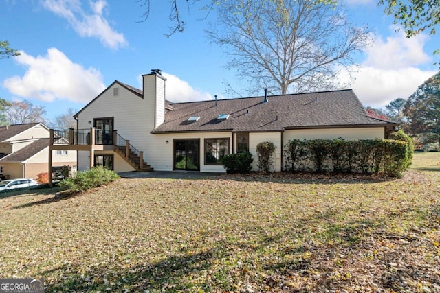 rear view of property with a lawn