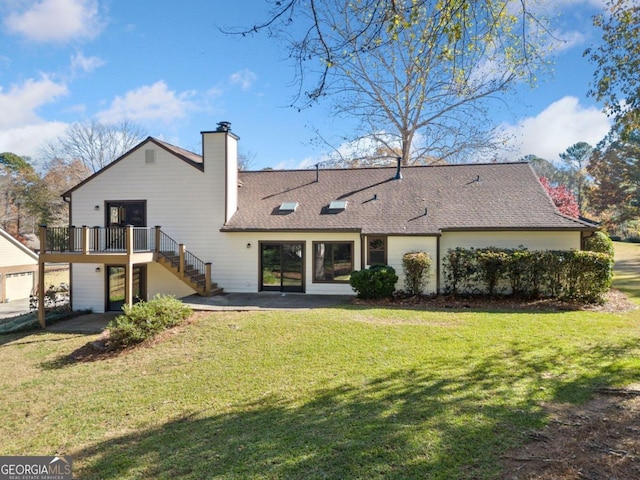 rear view of house with a yard, a patio, and a wooden deck