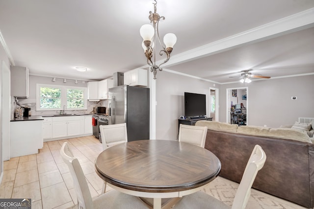 tiled dining space featuring sink, ceiling fan with notable chandelier, and ornamental molding