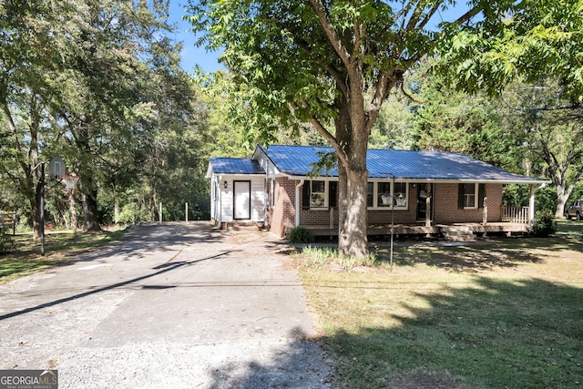 view of front of home featuring covered porch and a front lawn