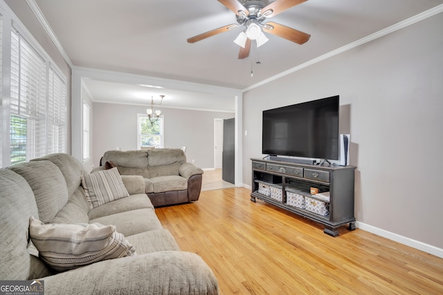 living room with hardwood / wood-style floors, ceiling fan with notable chandelier, and crown molding