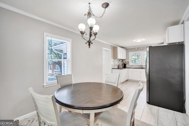 dining room featuring plenty of natural light, light tile patterned flooring, ornamental molding, and a chandelier