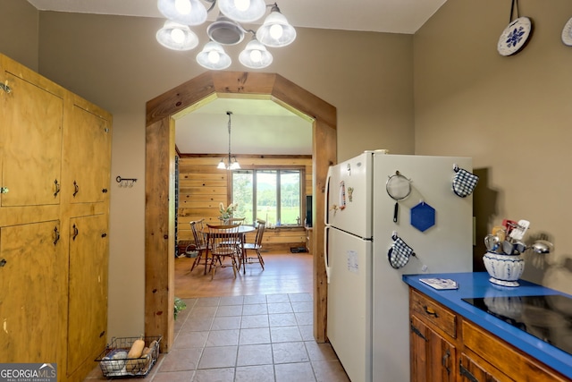 kitchen with a chandelier, white refrigerator, black electric cooktop, and light hardwood / wood-style flooring