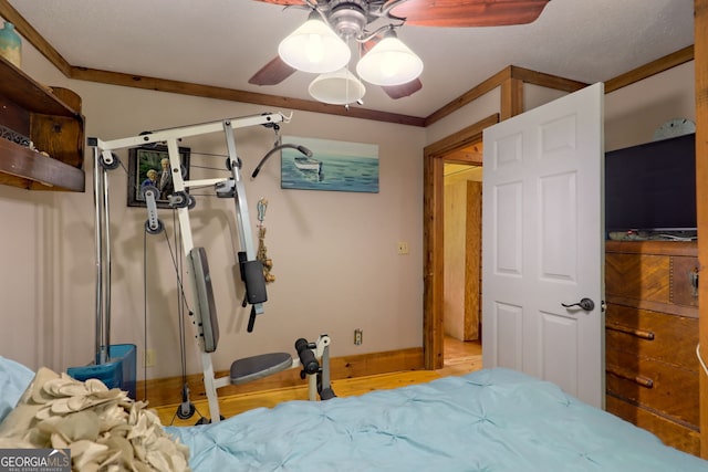 bedroom with a closet, ceiling fan, ornamental molding, and light hardwood / wood-style floors