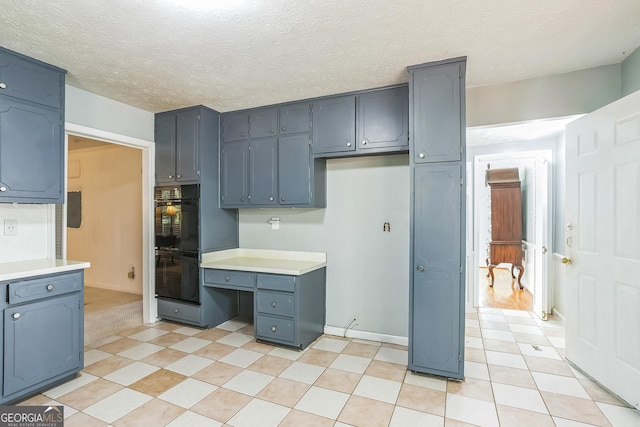 kitchen featuring black double oven and a textured ceiling