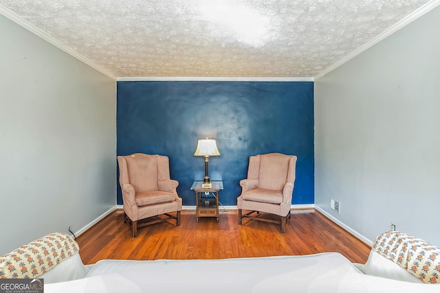 sitting room featuring hardwood / wood-style flooring and ornamental molding