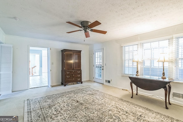 interior space with ceiling fan and a textured ceiling