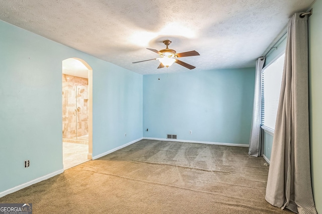 unfurnished room with carpet flooring, ceiling fan, and a textured ceiling