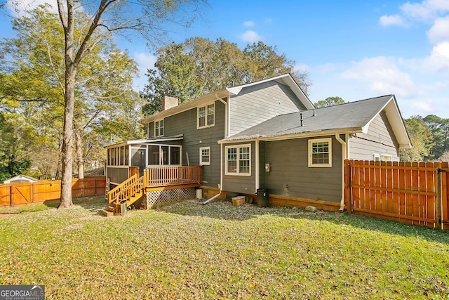 back of property with a sunroom, a yard, and a deck