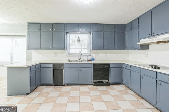 kitchen featuring kitchen peninsula, sink, black appliances, and a textured ceiling