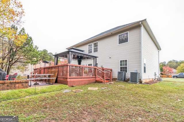 back of property featuring a gazebo, a wooden deck, a lawn, and central AC