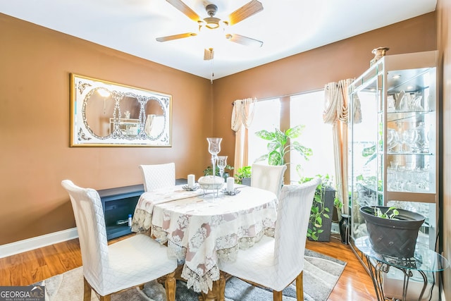 dining area with light wood-type flooring and ceiling fan