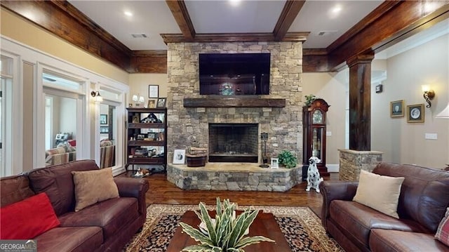 living room featuring a fireplace, hardwood / wood-style flooring, decorative columns, and crown molding