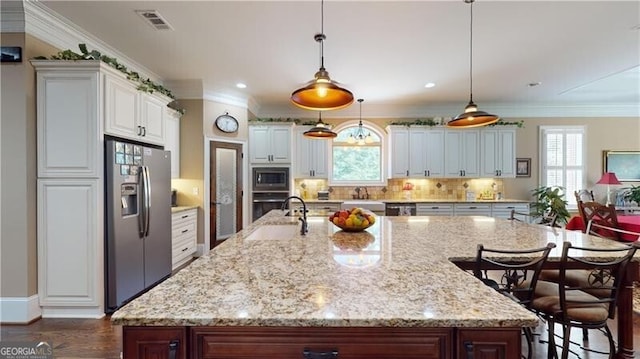 kitchen featuring a wealth of natural light, white cabinets, hanging light fixtures, and appliances with stainless steel finishes