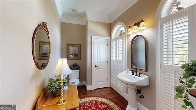 bathroom featuring toilet, wood-type flooring, and ornamental molding