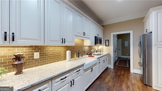 kitchen with stainless steel appliances, white cabinetry, and dark wood-type flooring