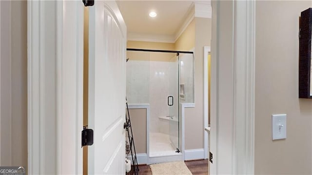 bathroom with an enclosed shower, wood-type flooring, and crown molding