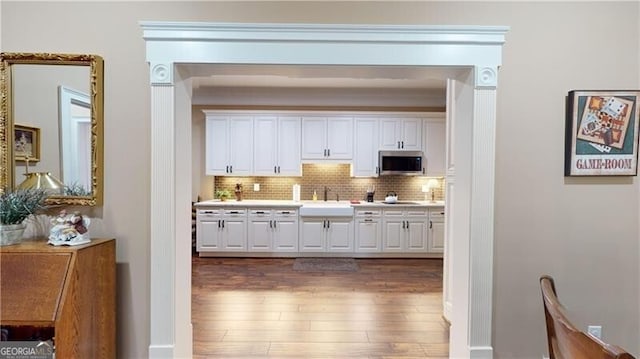 interior space with backsplash, white cabinetry, and dark hardwood / wood-style floors