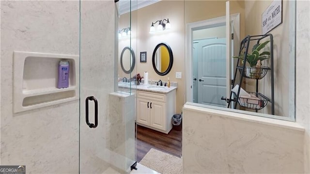 bathroom featuring hardwood / wood-style floors, vanity, and a shower with door