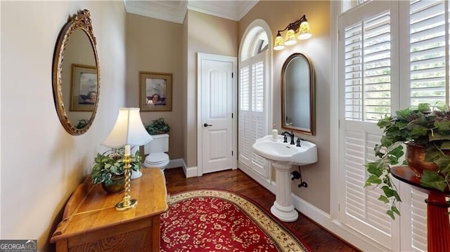 bathroom with hardwood / wood-style floors, toilet, and crown molding